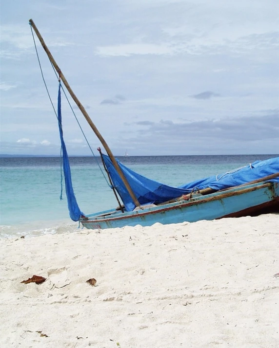 an old wooden boat sitting on the beach