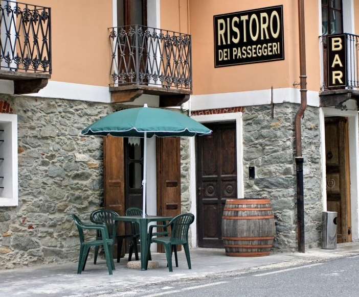 the tables and umbrella are outside of the bistro bar