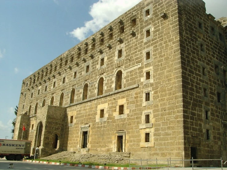 a tall stone building sitting on the side of a road