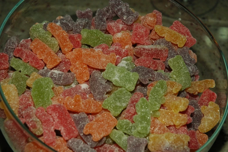 a glass bowl filled with gummy bears on top of a counter