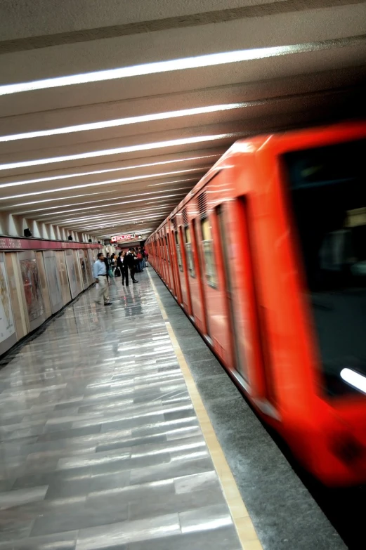 people are walking down a subway platform