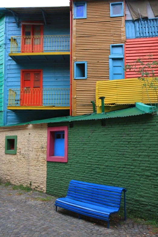 colorful building with wood planks and an outdoor blue bench