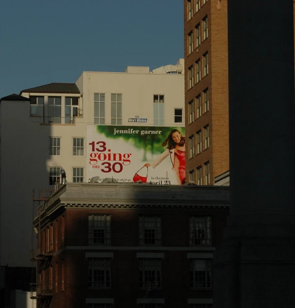 a tall white building has a large advertit on it