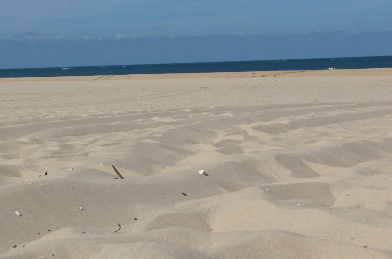 the sand has footprints in it and there is a beach