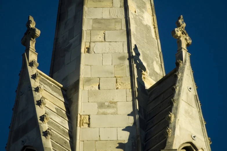 the tops of two spires with a bird statue on each of them