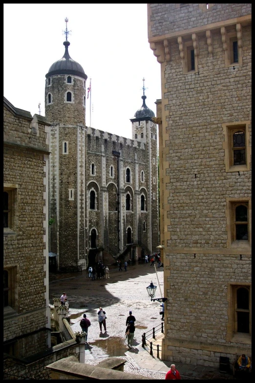 a group of people walking around a tall castle