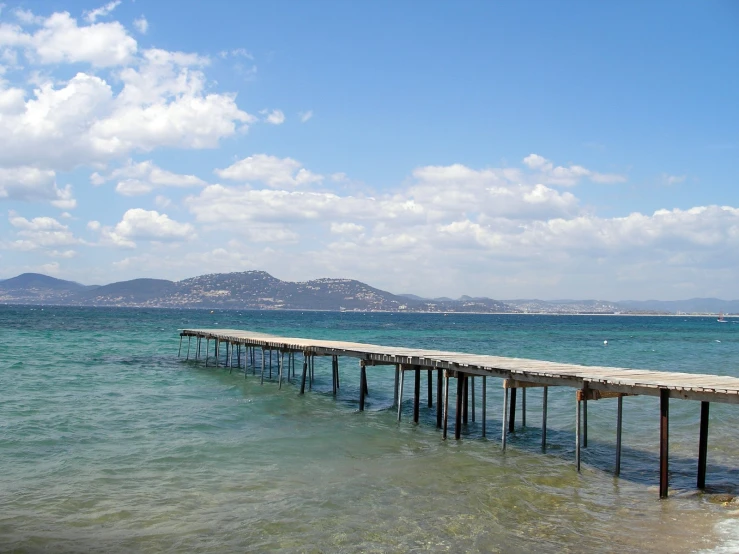 a long jetty in the ocean near a shore