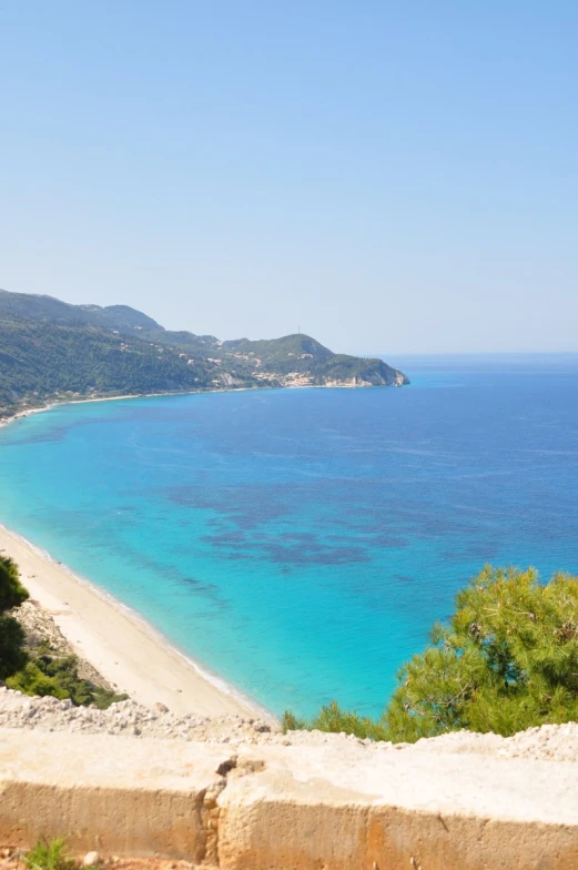 a beautiful beach next to the ocean with blue water