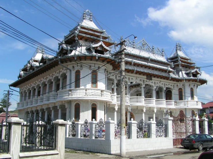 a white house with black fence and a blue sky