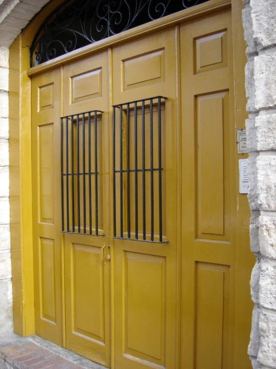 two doors in a house that has a wrought iron grilled top