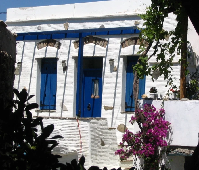 a house with blue doors and some bushes