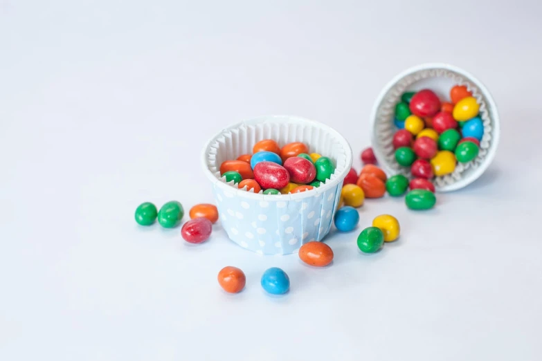 a cup full of multi colored candy with the lid off