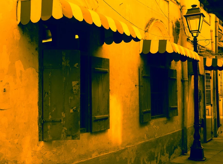 an old building is painted yellow and has a big awning on it