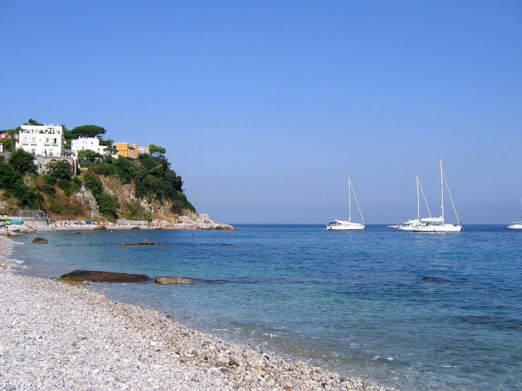 boats sailing by the rocky shore of a small cove