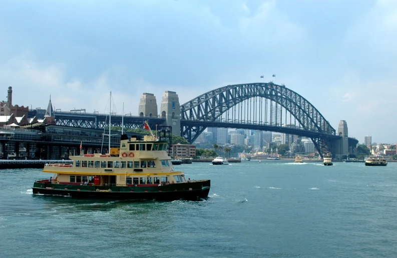 a boat cruises under an bridge as boats pass