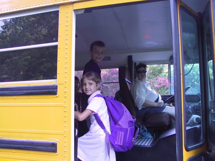 children are getting off the bus waiting to board the bus