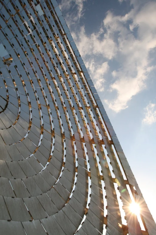 the top portion of a building with a sun in the background