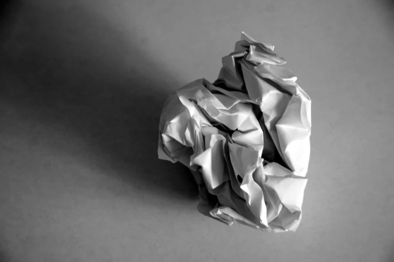 a crumpled white paper on a gray table