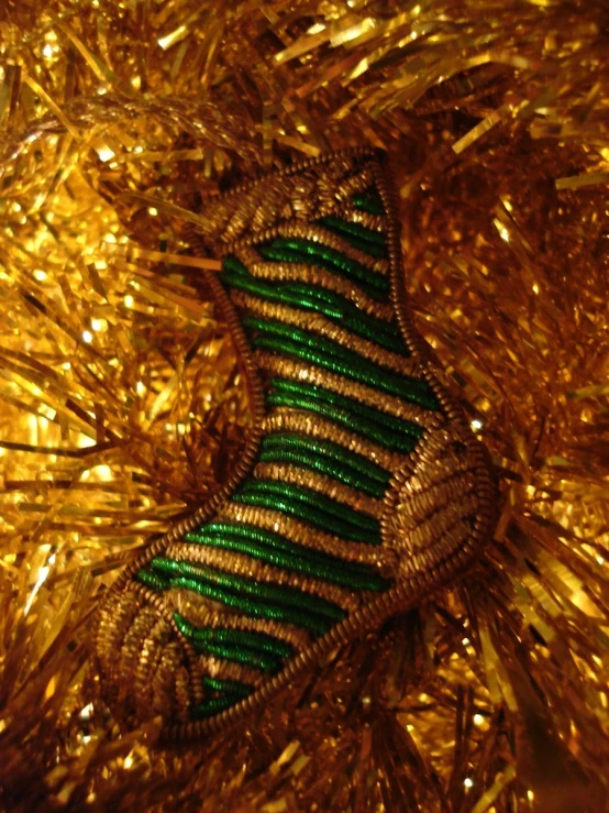 a gold, green and silver wire decoration
