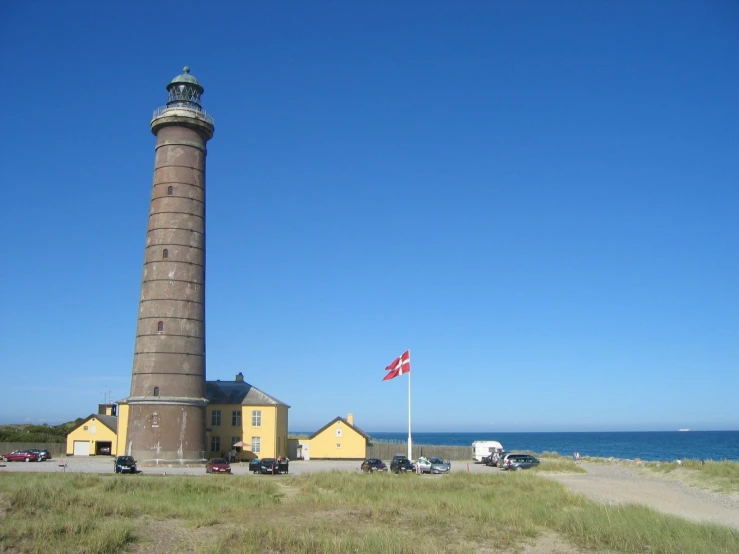 a tall tower next to a grassy field and beach