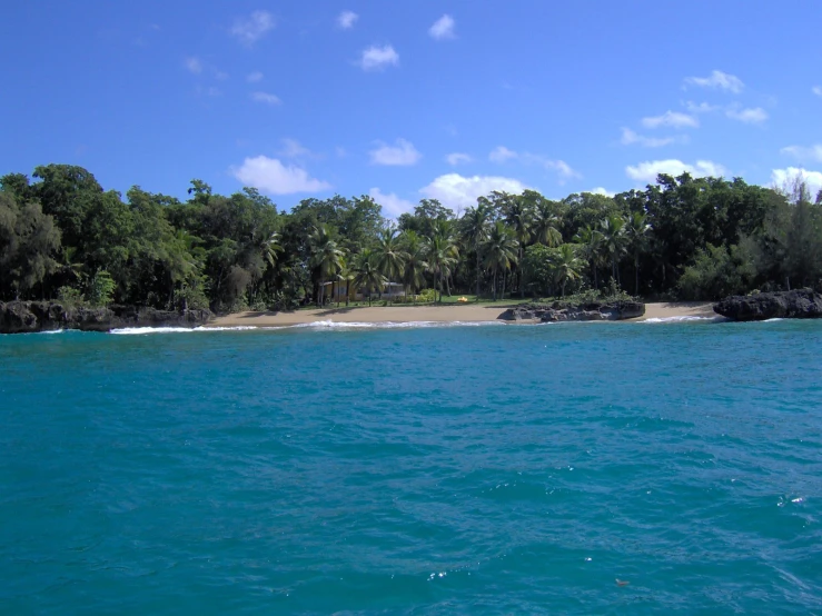 an island sitting in the middle of some blue water