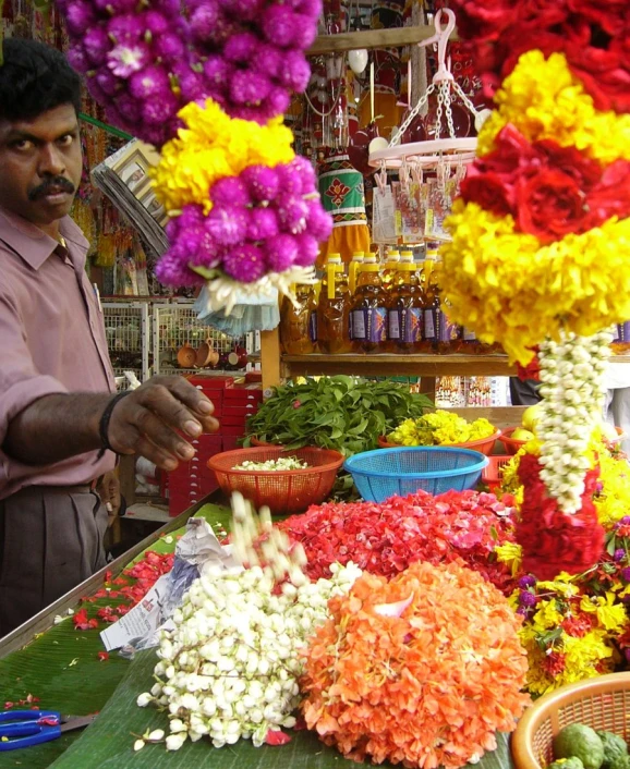 a man is selling flowers at a market