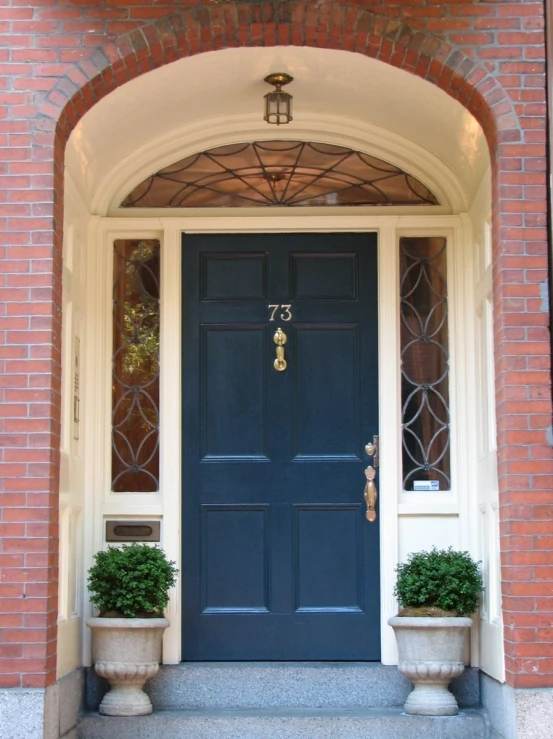 a blue door with two planters at the bottom of it