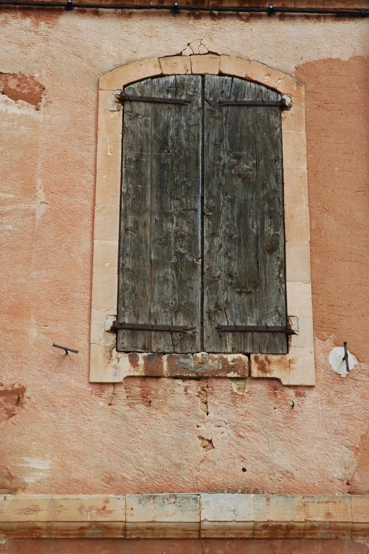 an old brown building with an open window