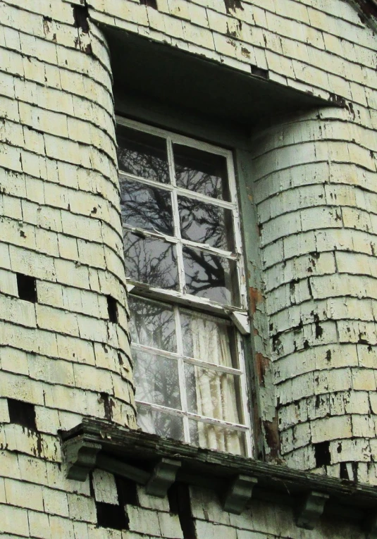 the window of an abandoned building looks old