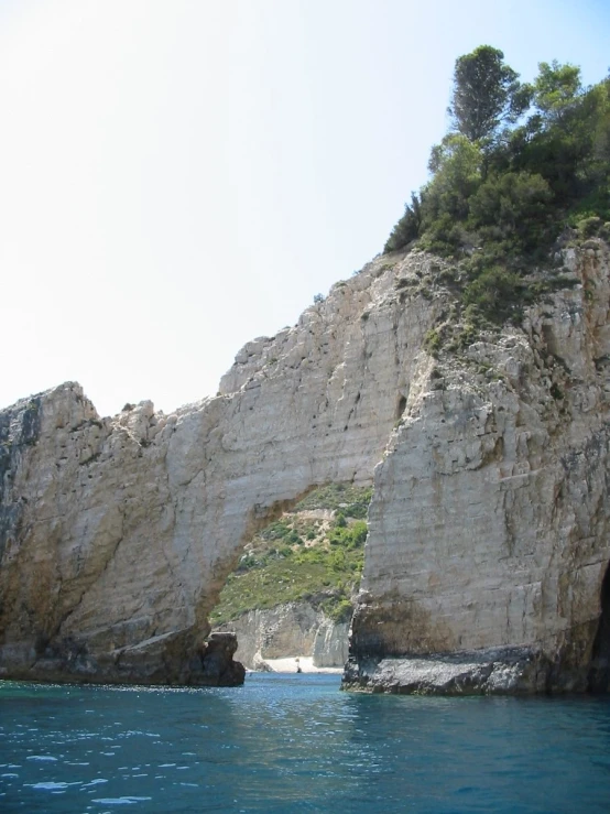 there are rock formations along the water, near the shore