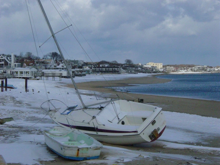 a boat and another small sailboat stranded in the beach