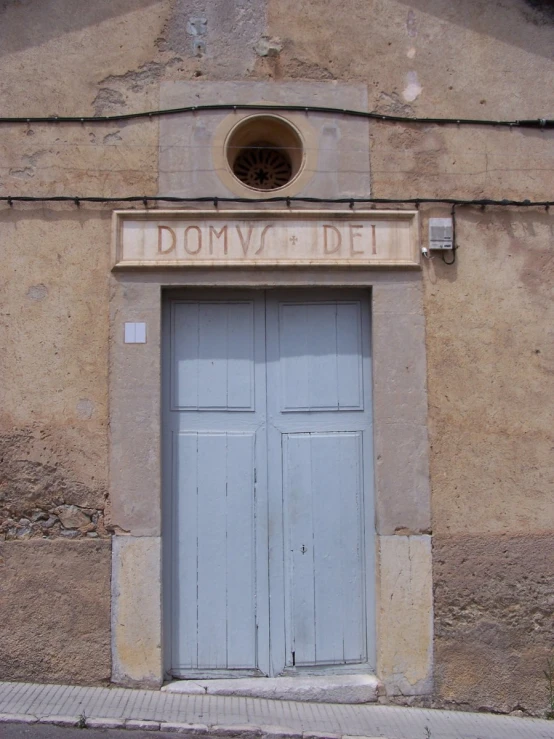 a building with two wooden doors and a circular doorway