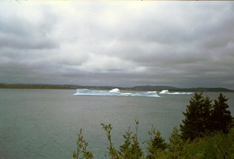 the water has two large icebergs on the horizon