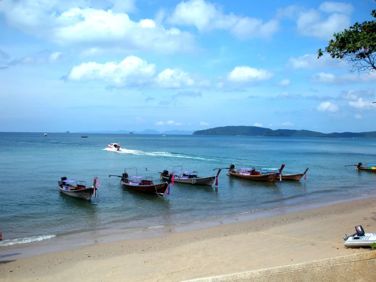 small fishing boats in the ocean water near a beach