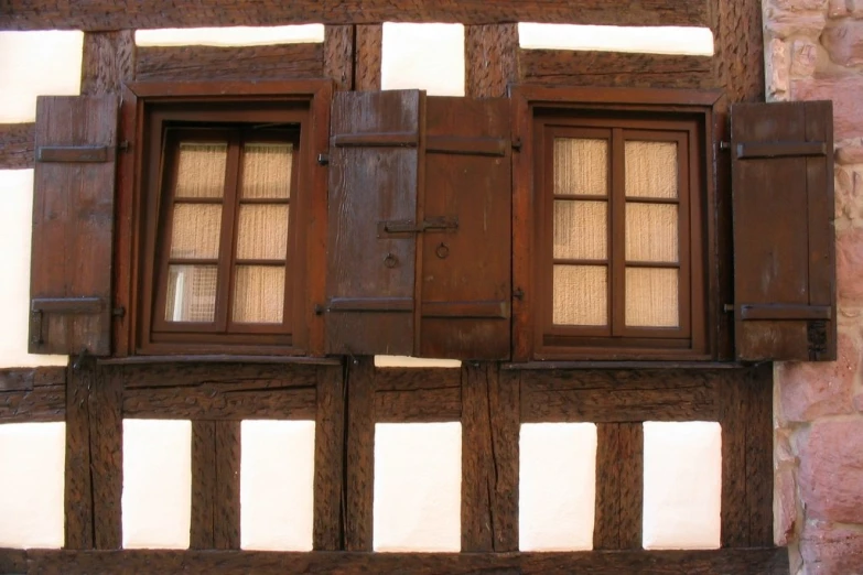 two brown windows are open on an old building