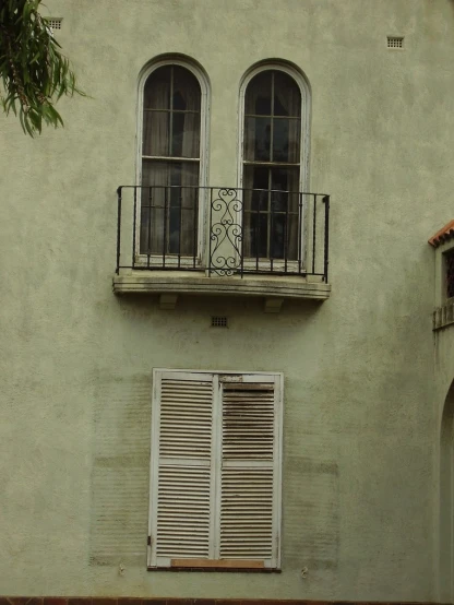 a window and shutters on the side of a building