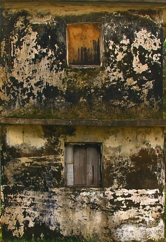an old building with the door open in grass