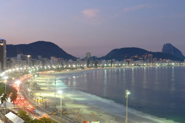 the city lights shine brightly on a beach at night