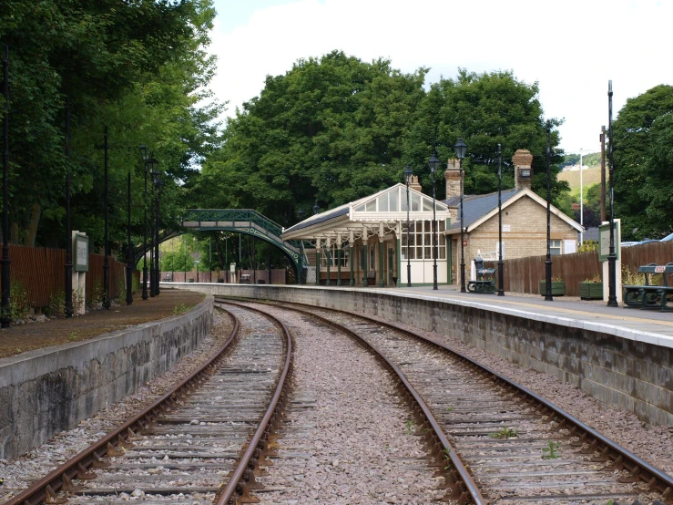 the railroad track runs between a building and the trees