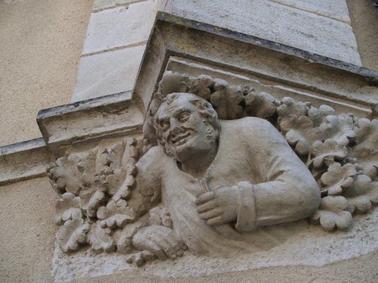 an old statue is posed on the wall of the building