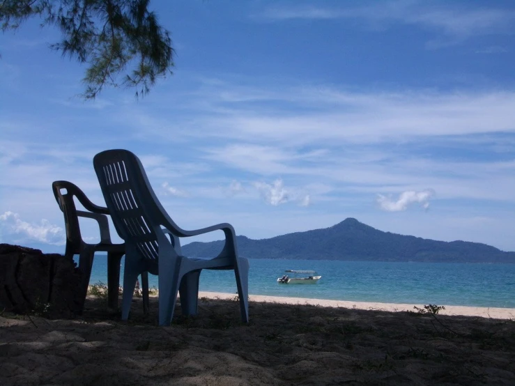 there is a chair and two chairs next to a body of water