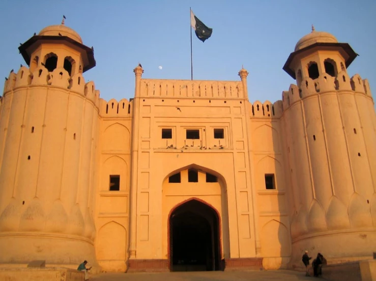 a large white building with two towers and a flag flying high