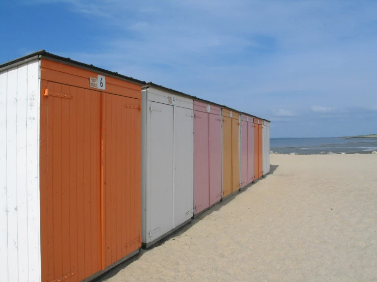 a long row of colorful and white beach cabins