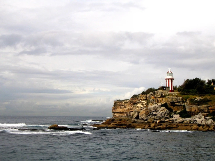 a lighthouse on top of a rock in the ocean