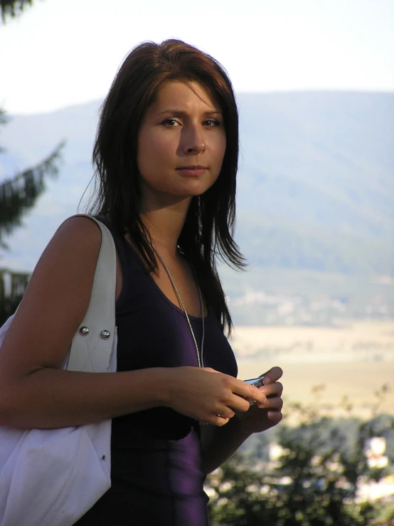 a woman standing looking at her cellphone