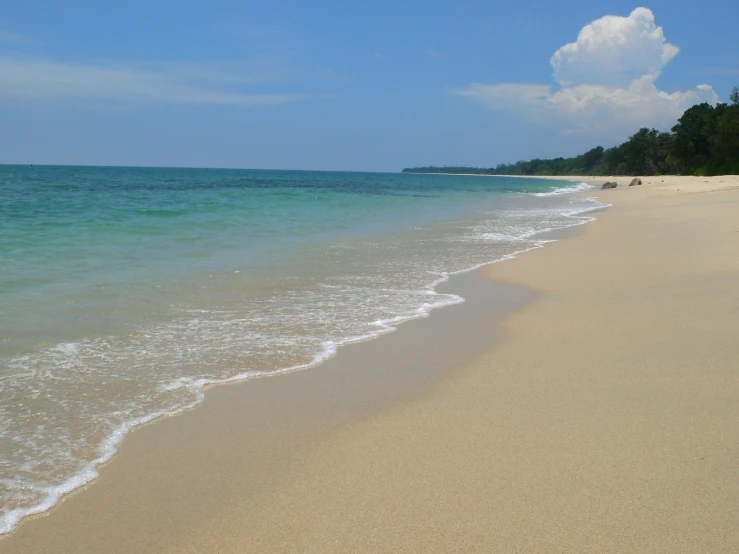 a beach scene with a few waves coming in