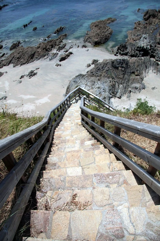 the stairs lead down to the beach, leading to the ocean