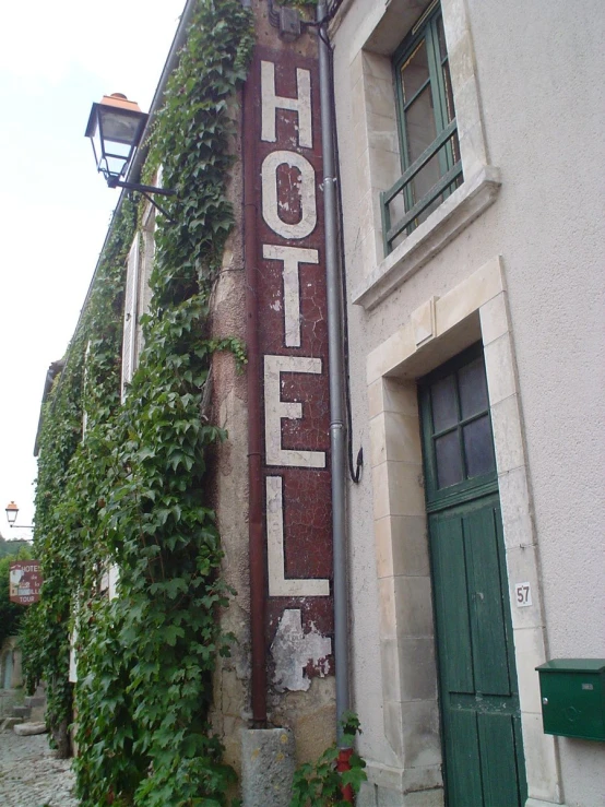 a el sign that is covered with ivy next to the building