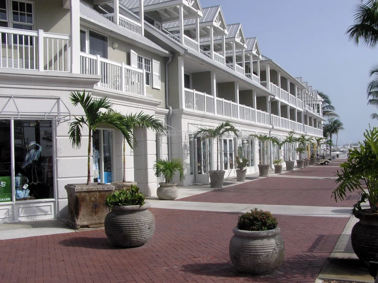 an empty brick walkway leads to rows of resort rooms on stilts