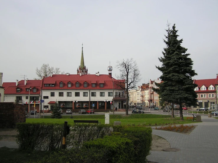 a small building with a red roof and trees next to it